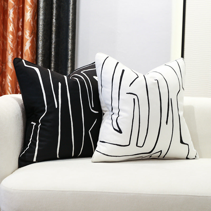 Close-up of minimalist black and white throw pillow with abstract lines
