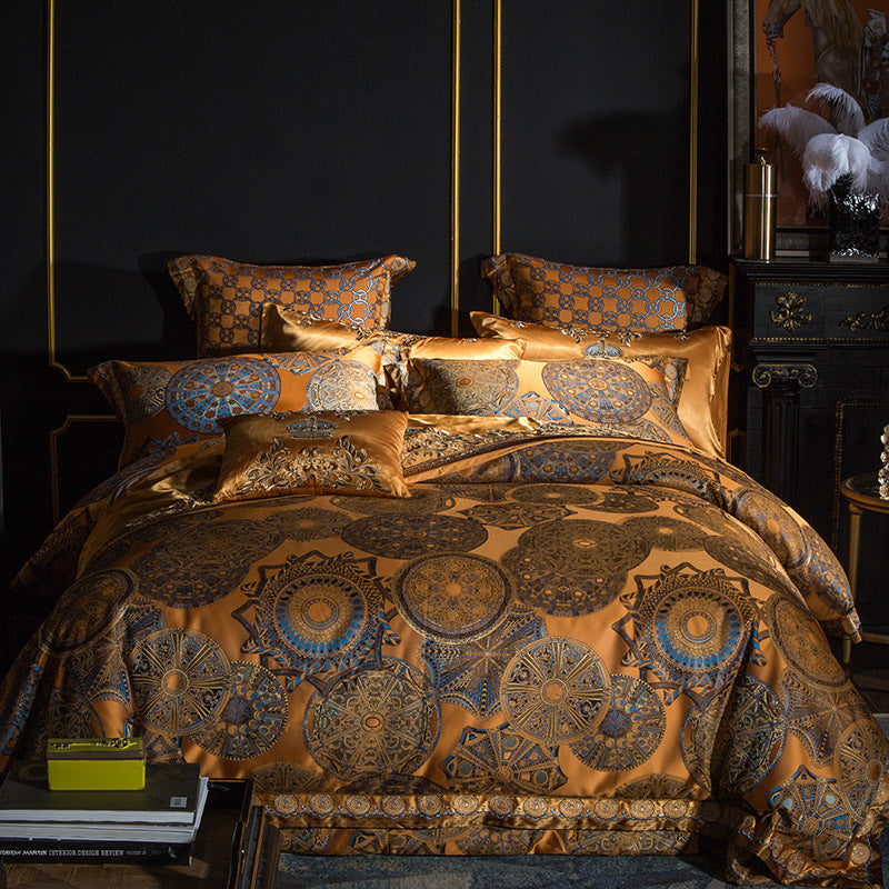 Decorative bedspread with intricate patterns in a darkly decorated room.